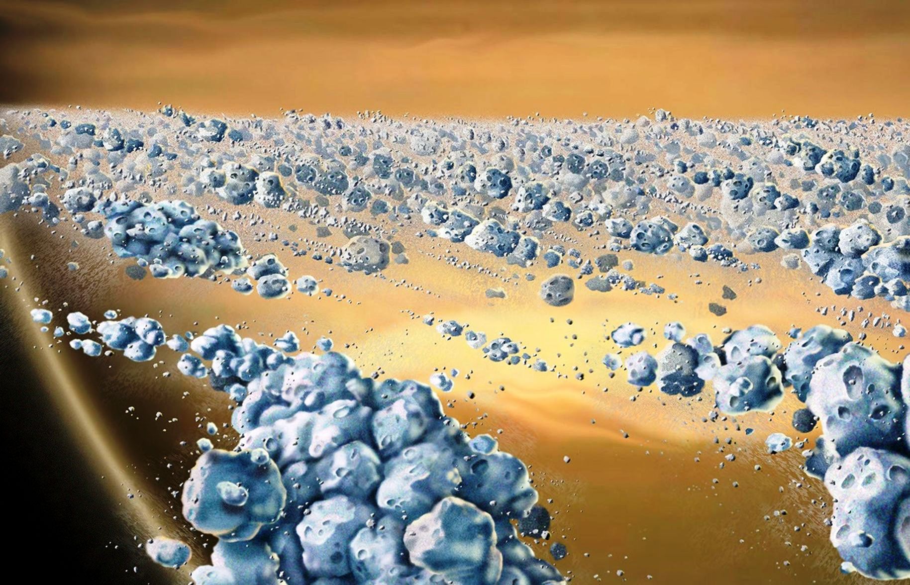Il s'agit d'une vue d'artiste en gros plan des particules des anneaux de Saturne. La planète Saturne apparaît en arrière-plan (jaune et marron). Les particules (bleues) sont principalement composées de glace, mais ne sont pas uniformes. Elles s'agglutinent pour former des agrégats allongés et incurvés, se formant et se dispersant continuellement. L'espace entre les amas est presque vide. Les plus grosses particules individuelles présentées mesurent quelques mètres de diamètre. Image de Marty Peterson, d'après une image de William K. Hartmann de 1984. L'image de Hartmann illustre les premières recherches de Stuart Weidenschilling et de ses collègues du Planetary Science Institute sur les corps éphémères dynamiques dans les anneaux de Saturne. © Nasa JPL University of Colorado, Marty Peterson
